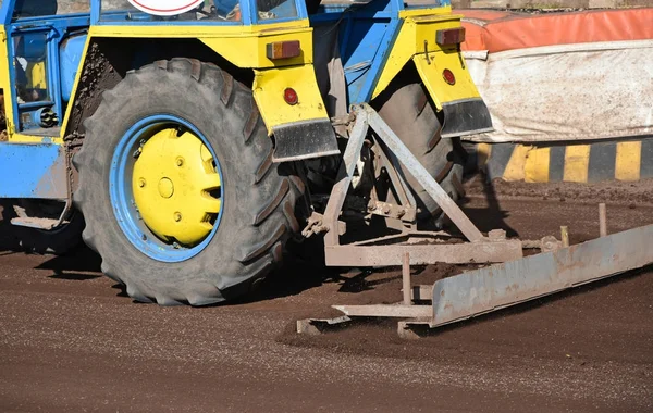 Traktor vyhladí cestu na dirty sportovní dráze — Stock fotografie