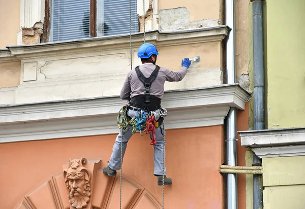 Pracownik budowlany w pracy na ścianie starego budynku — Zdjęcie stockowe