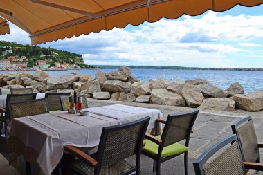 Masa ve sandalye bir restoranın denize sıfır, Trieste, İtalya