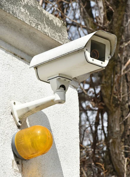 Камера видеонаблюдения и безопасное освещение у входа — стоковое фото