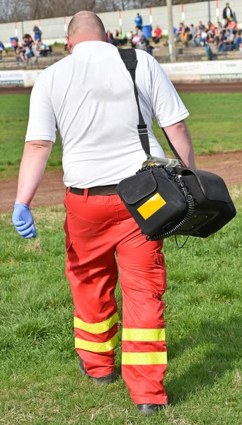 Personal de ambulancia con equipo médico en una pista deportiva —  Fotos de Stock