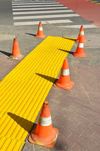 Cones de tráfego na calçada ao lado de uma travessia de zebra — Fotografia de Stock