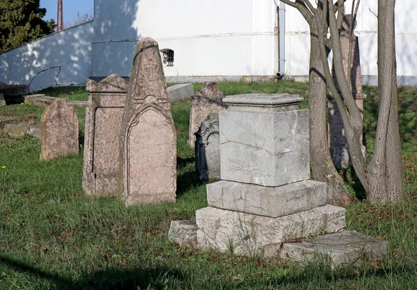 Grafstenen op de oude begraafplaats bij een kapel — Stockfoto