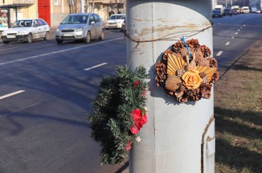 Anma çelenkleri yolun yanındaki direkte.