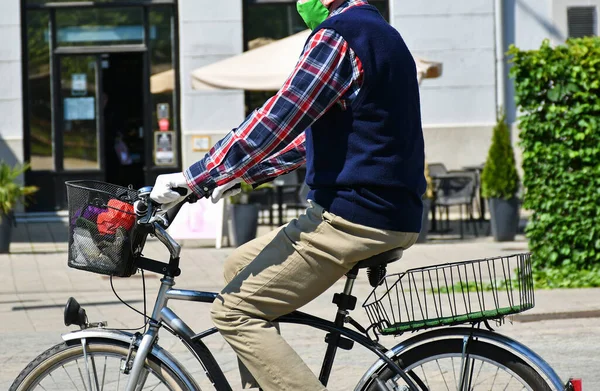 Man rides a bicycle in a protective mask