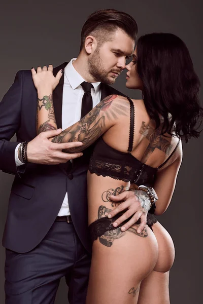 Retrato de un hombre brutal en traje y chica sexy — Foto de Stock