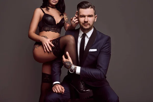 Retrato de un hombre brutal en traje y chica sexy — Foto de Stock