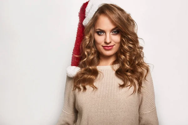 Vacker positiva blondin i en tröja och festlig mössa — Stockfoto