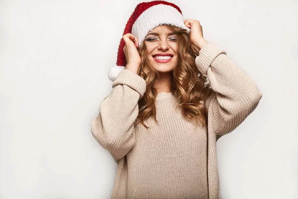 Όμορφη ξανθιά θετικά σε ένα πουλόβερ και εορταστική ΚΑΠ — Φωτογραφία Αρχείου