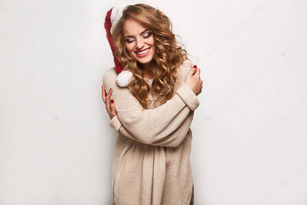 Beautiful positive blonde in a sweater and festive cap