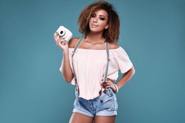 Elegant black woman model with curly hair and camera