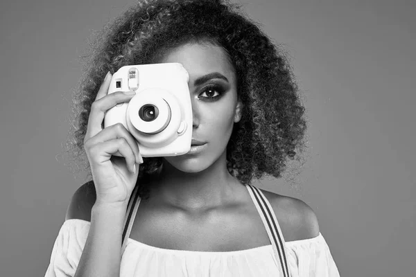 Modelo elegante mulher preta com cabelo encaracolado e câmera — Fotografia de Stock