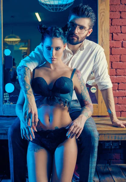 Acımasız adam şık takım elbise ve dövmeli seksi kız