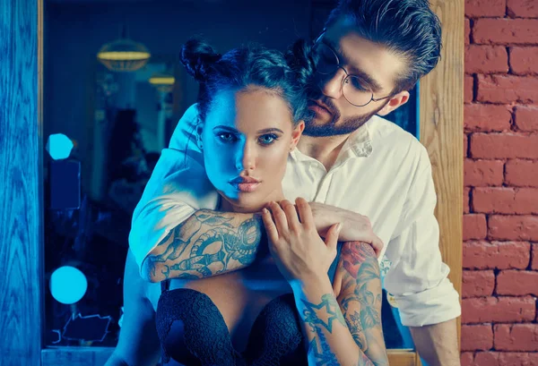 Acımasız adam şık takım elbise ve dövmeli seksi kız — Stok fotoğraf