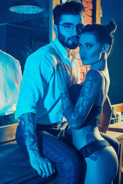 Acımasız adam şık takım elbise ve dövmeli seksi kız