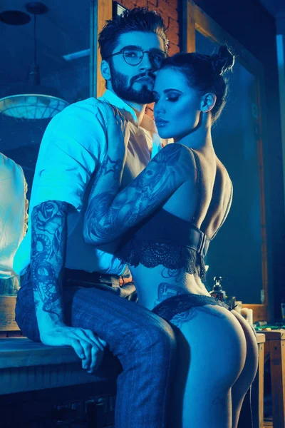Acımasız adam şık takım elbise ve dövmeli seksi kız