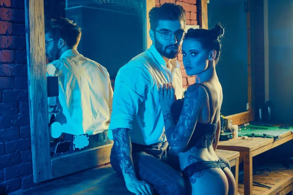 Acımasız adam şık takım elbise ve dövmeli seksi kız
