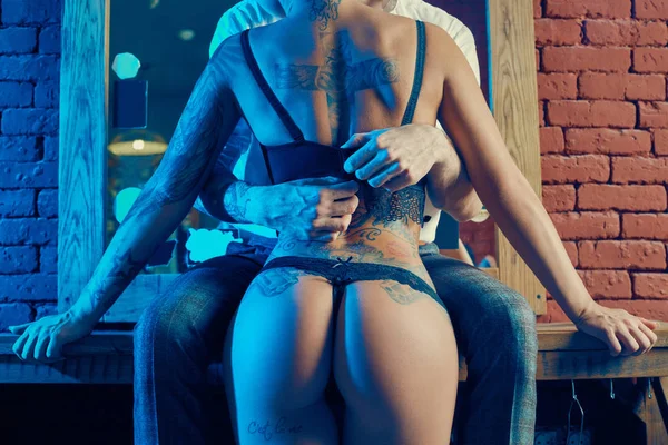 Acımasız adam şık takım elbise ve dövmeli seksi kız