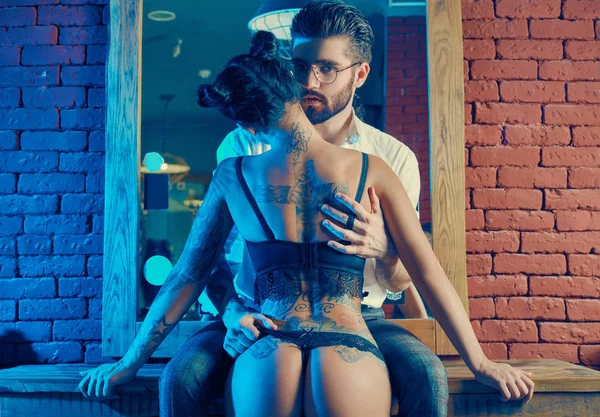 Acımasız adam şık takım elbise ve dövmeli seksi kız