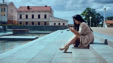 Sevimli ve güzel Asyalı kadın basamaklarında oturan ceket