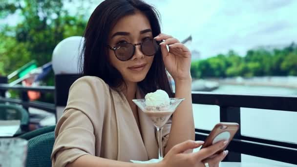 Portret van een schattig en prachtige Aziatische vrouw met ijs en telefoon — Stockvideo