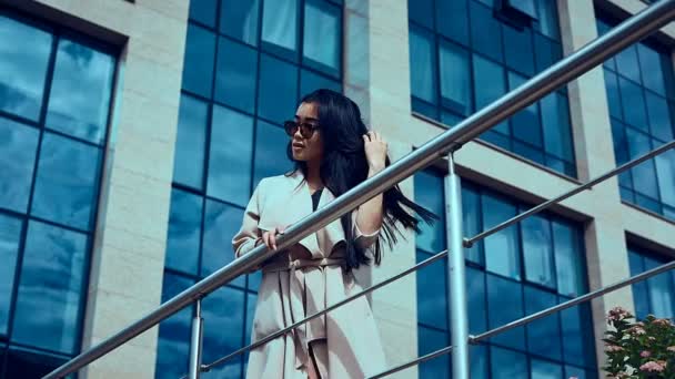 Söt och vacker asiatisk kvinna i mode kappa nära blå Businesscenter — Stockvideo