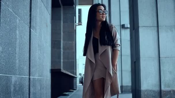 Süße und hinreißende asiatische Frau im Mantel, die zwischen den Säulen wandelt — Stockvideo