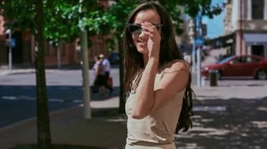 Sevimli ve güzel latin kadın poz ve alongn street gülümseyen elbiseli