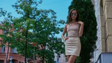 Sevimli ve güzel latin kadın poz ve alongn street gülümseyen elbiseli