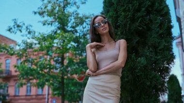 Sevimli ve güzel latin kadın poz ve alongn street gülümseyen elbiseli