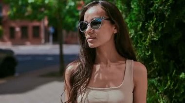 Sevimli ve güzel latin kadın poz ve alongn street gülümseyen elbiseli