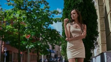 Sevimli ve güzel latin kadın poz ve alongn street gülümseyen elbiseli