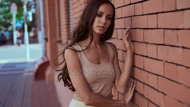 Sevimli ve güzel latin kadın elbiseli bir tuğla duvara poz — Stok video