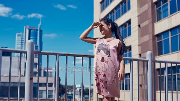 Mujer asiática linda y brillante en vestido de moda admirando la vista de la ciudad — Vídeos de Stock