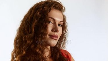 Studio beyaz arka plan üzerinde poz kıvırcık saçlı esmer kadın