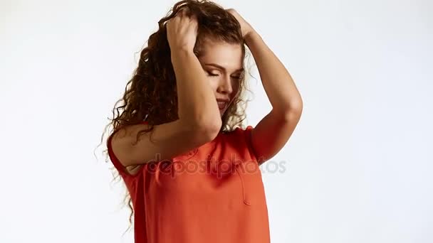 Brunette woman with curly hair posing on white background in studio — Stock Video