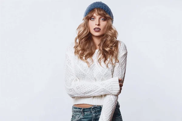 Pozitivní, Blondýnka v svetr a čepice izolovaných na bílém pozadí — Stock fotografie
