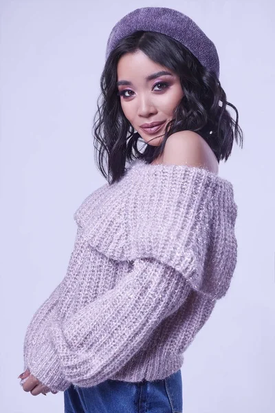 Gyönyörű bájos ázsiai lány lila pulóverben világos háttér — Stock Fotó