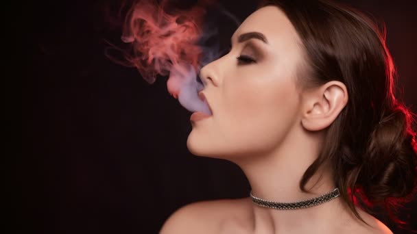 グラマー魅惑的なゴージャスなブルネットの女性は スタジオ内には電子タバコを吸ってのスローモーションの肖像画 — ストック動画