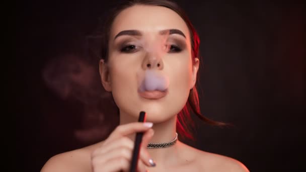 Zpomalený pohyb portrét glamour svůdné nádherná bruneta žena kouření elektronické cigarety ve studiu