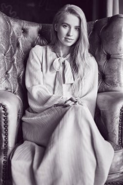 Deri oturma pembe elbiseli güzel zarif sarışın kadın 