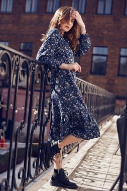 Balkonda yaz mavi elbise giyen güzel zarif esmer kadın