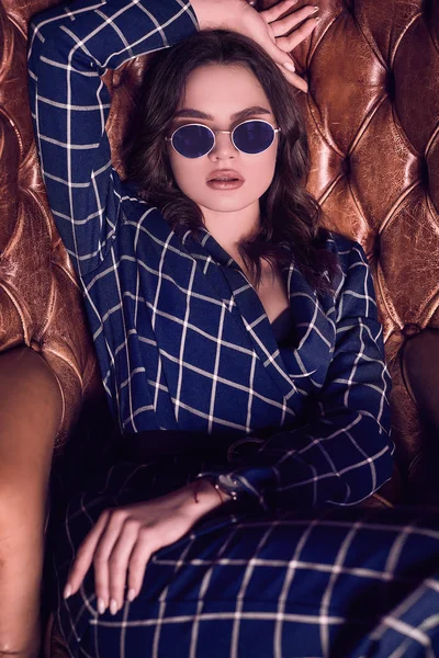 Deri koltukta oturan mavi elbiseli güzel zarif kadın