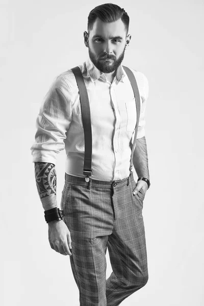 Brutal elegant man in gray classic pants and suspenders isolated — Stock Photo, Image