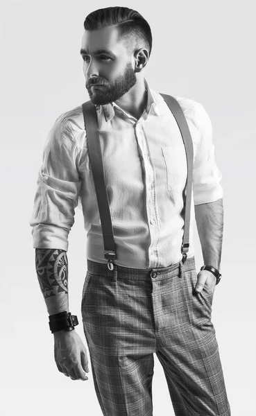 Brutaler eleganter Mann in grauer klassischer Hose und Hosenträgern isoliert — Stockfoto