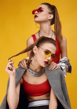 Moda kırmızısı bluzlu, siyah şortlu iki zarif hippi kız.