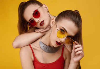 Moda kırmızısı bluzlu, siyah şortlu iki zarif hippi kız.