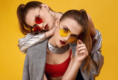 Moda kırmızısı bluzlu, siyah şortlu iki zarif hippi kız.