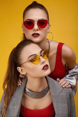 Moda kırmızısı bluzlu, siyah şortlu iki zarif hippi kız.