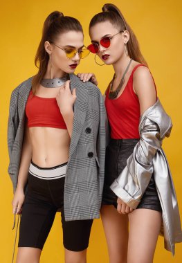 Moda kırmızısı bluzlu, siyah şortlu iki zarif hippi kız.